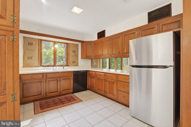 20 Birch Ct, Lancaster, PA 17603 - kitchen with freestanding refrigerator, dishwasher, brown cabinets, light countertops, and light tile patterned floors
