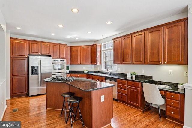 5570 La Vista Dr, Alexandria, VA 22310 - kitchen featuring appliances with stainless steel finishes, a kitchen bar, recessed lighting, a kitchen island, and light wood finished floors