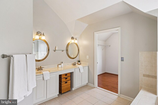 5570 La Vista Dr, Alexandria, VA 22310 - full bathroom featuring vaulted ceiling, tile patterned flooring, double vanity, and a spacious closet