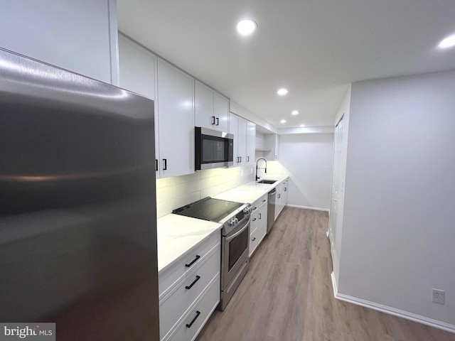7720 Tremayne Pl Unit 107, Mclean, VA 22102 - kitchen with stainless steel appliances, white cabinets, tasteful backsplash, light wood finished floors, and light stone counters