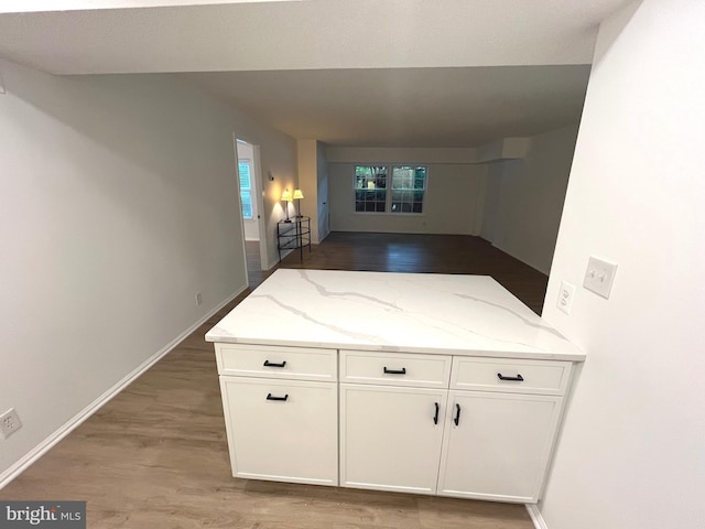 7720 Tremayne Pl Unit 107, Mclean, VA 22102 - kitchen with white cabinetry, light stone countertops, wood finished floors, and open floor plan