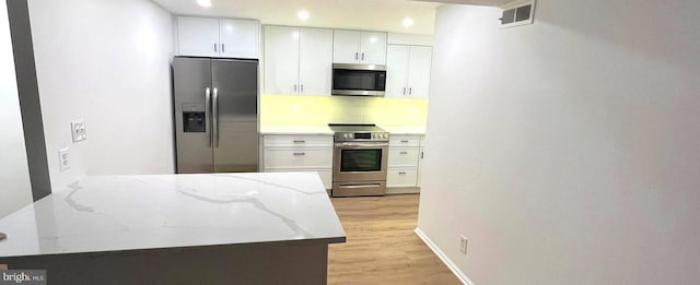 7720 Tremayne Pl Unit 107, Mclean, VA 22102 - kitchen featuring appliances with stainless steel finishes, white cabinets, light wood finished floors, light stone countertops, and recessed lighting