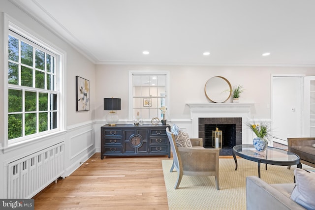 7819 Overbrook, Ruxton, MD 21204 - living room featuring radiator heating unit, light wood-type flooring, a fireplace, wainscoting, and ornamental molding