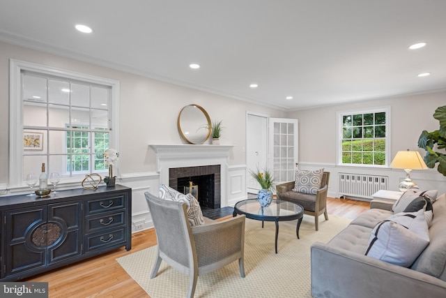 7819 Overbrook, Ruxton, MD 21204 - living area featuring radiator heating unit, a wainscoted wall, a brick fireplace, light wood-type flooring, and recessed lighting