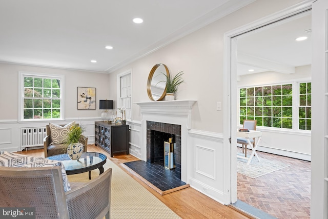 7819 Overbrook, Ruxton, MD 21204 - living area featuring radiator heating unit, ornamental molding, a fireplace with raised hearth, a wainscoted wall, and a baseboard heating unit