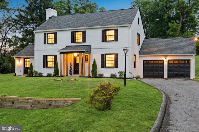 7819 Overbrook, Ruxton, MD 21204 - view of front facade with a chimney, asphalt driveway, a garage, a front lawn, and brick siding