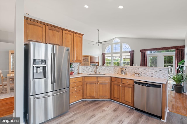 3709 Apple Cider Ct, Dumfries, VA 22025 - kitchen featuring stainless steel appliances, a peninsula, light wood-style floors, light countertops, and lofted ceiling