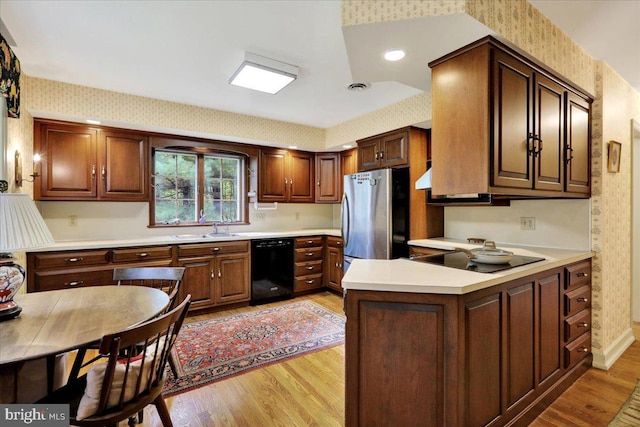 154 Deer Hill Rd, Reading, PA 19607 - kitchen featuring black appliances, wallpapered walls, light wood-style flooring, light countertops, and a peninsula