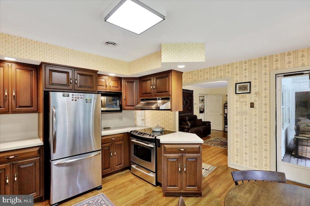154 Deer Hill Rd, Reading, PA 19607 - kitchen featuring appliances with stainless steel finishes, wallpapered walls, under cabinet range hood, light wood finished floors, and light countertops
