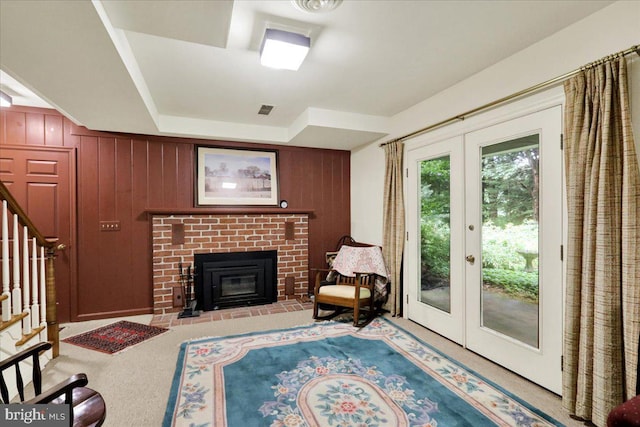 154 Deer Hill Rd, Reading, PA 19607 - living room with french doors, stairway, carpet flooring, wood walls, and a brick fireplace