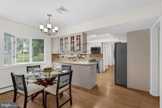 69 Hickory Ln, Chalfont, PA 18914 - dining area featuring a chandelier, light wood-style floors, and a baseboard radiator
