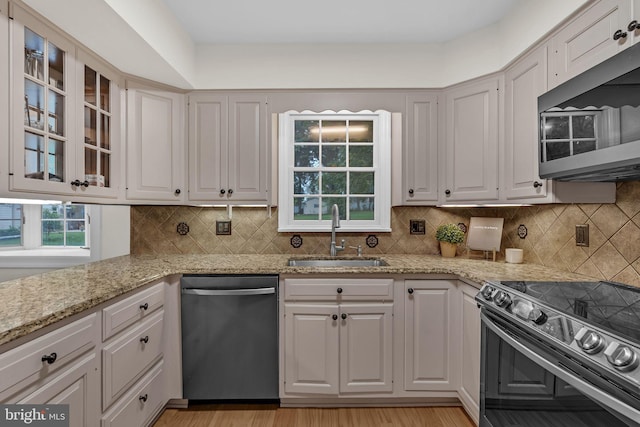 69 Hickory Ln, Chalfont, PA 18914 - kitchen with stainless steel appliances, light stone counters, backsplash, and glass insert cabinets