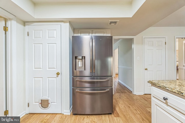 69 Hickory Ln, Chalfont, PA 18914 - kitchen with stainless steel refrigerator with ice dispenser, light wood finished floors, light stone countertops, and white cabinets