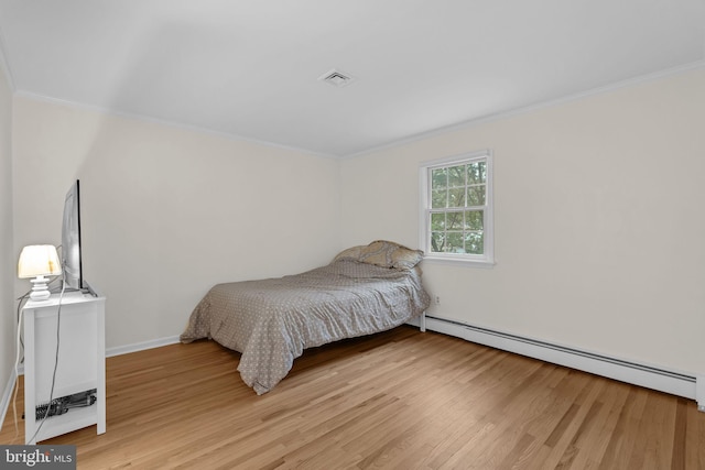 69 Hickory Ln, Chalfont, PA 18914 - bedroom featuring a baseboard heating unit, crown molding, and light wood-style floors