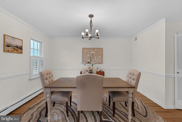 69 Hickory Ln, Chalfont, PA 18914 - dining room with a baseboard radiator, a chandelier, wood finished floors, and ornamental molding