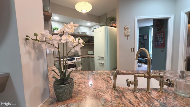 715 6th St NW Unit 1002, Washington, DC 20001 - kitchen with freestanding refrigerator, open shelves, gas stove, and stone countertops