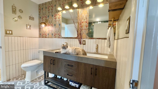 715 6th St NW Unit 1002, Washington, DC 20001 - bathroom featuring double vanity, tile patterned flooring, wainscoting, and wallpapered walls