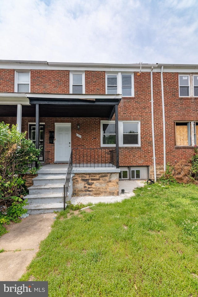 1304 N Linwood Ave, Baltimore, MD 21213 - townhome / multi-family property featuring brick siding, a front lawn, and covered porch
