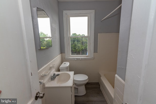 1304 N Linwood Ave, Baltimore, MD 21213 - bathroom with vanity, healthy amount of natural light, tile walls, wood finished floors, and a tub
