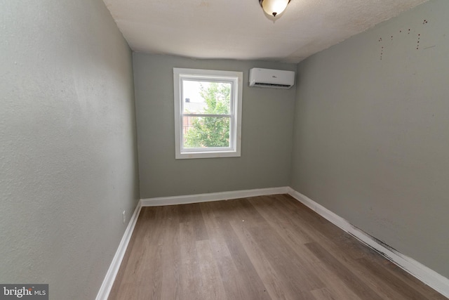 1304 N Linwood Ave, Baltimore, MD 21213 - spare room with an AC wall unit and wood finished floors