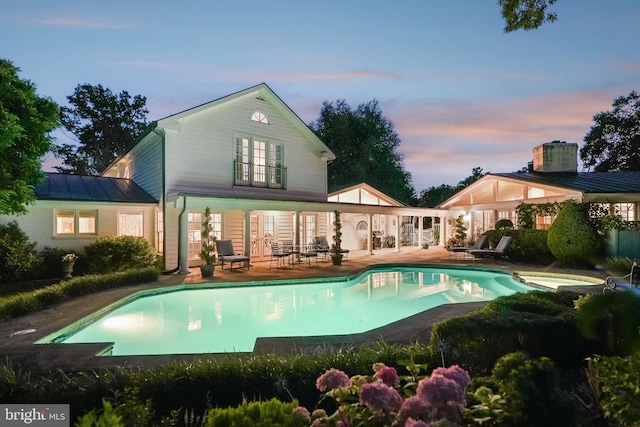 3201/2 Mansion Dr, Alexandria, VA 22302 - rear view of property featuring french doors, a patio, an outdoor pool, and a standing seam roof