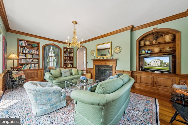 3201/2 Mansion Dr, Alexandria, VA 22302 - living area featuring built in shelves, arched walkways, ornamental molding, a wainscoted wall, and a high end fireplace