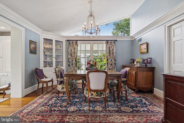 3201/2 Mansion Dr, Alexandria, VA 22302 - dining space featuring a chandelier, wood finished floors, vaulted ceiling, and crown molding