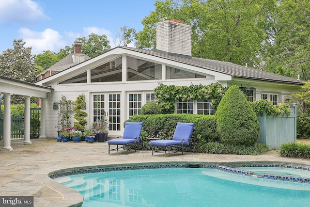 3201/2 Mansion Dr, Alexandria, VA 22302 - back of property featuring french doors, a chimney, a patio area, and a pool with connected hot tub