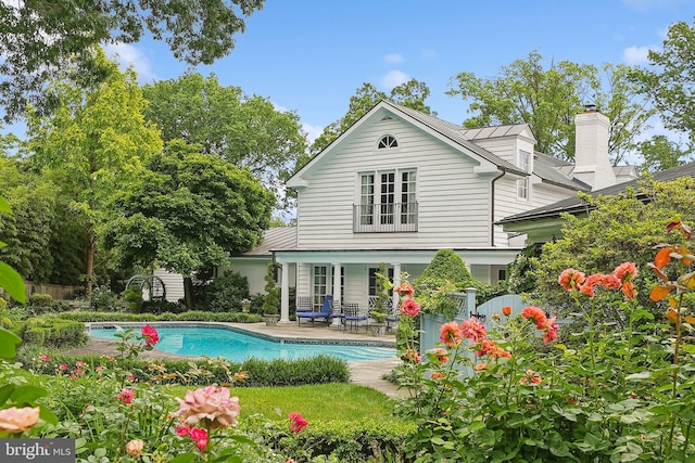 3201/2 Mansion Dr, Alexandria, VA 22302 - rear view of property featuring an outdoor pool, a patio, and a chimney