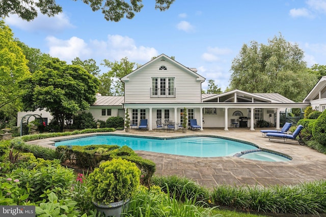 3201/2 Mansion Dr, Alexandria, VA 22302 - rear view of house featuring a patio, a standing seam roof, french doors, a metal roof, and a pool with connected hot tub