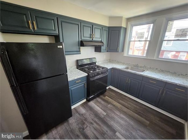 3322 Elmora Ave, Baltimore, MD 21213 - kitchen with black appliances, under cabinet range hood, dark wood-style flooring, and light stone counters