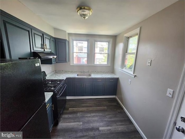 3322 Elmora Ave, Baltimore, MD 21213 - kitchen with black appliances, exhaust hood, and dark wood finished floors