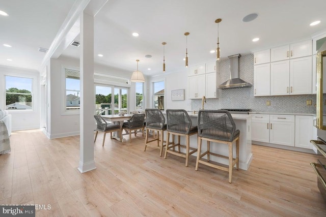 1 Capstan Rd, Waretown, NJ 08758 - kitchen featuring wall chimney range hood, healthy amount of natural light, tasteful backsplash, a kitchen breakfast bar, and recessed lighting