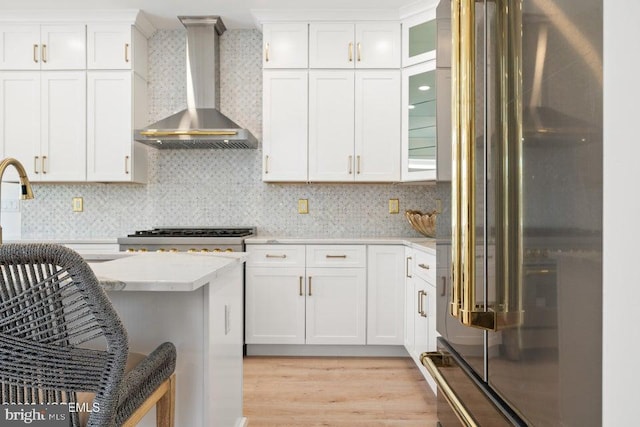 1 Capstan Rd, Waretown, NJ 08758 - kitchen featuring high quality fridge, wall chimney exhaust hood, white cabinets, light wood-type flooring, and light stone countertops