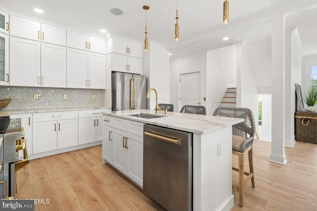 1 Capstan Rd, Waretown, NJ 08758 - kitchen featuring appliances with stainless steel finishes, ornamental molding, white cabinets, a kitchen breakfast bar, and light wood-style flooring