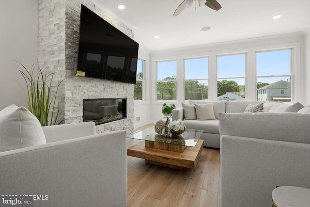 1 Capstan Rd, Waretown, NJ 08758 - living area with a stone fireplace, wood finished floors, ceiling fan, ornamental molding, and recessed lighting