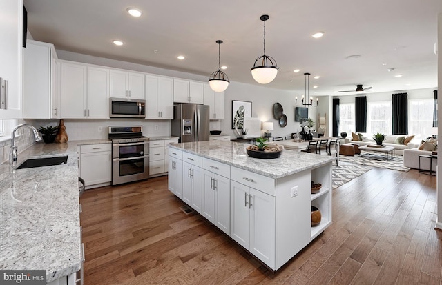 1106 Crested Wood Dr, Laurel, MD 20724 - kitchen featuring stainless steel appliances, open shelves, wood finished floors, white cabinets, and open floor plan