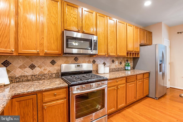 20114 Gunners Ter, Germantown, MD 20876 - kitchen with appliances with stainless steel finishes, light wood-style flooring, tasteful backsplash, and light stone countertops