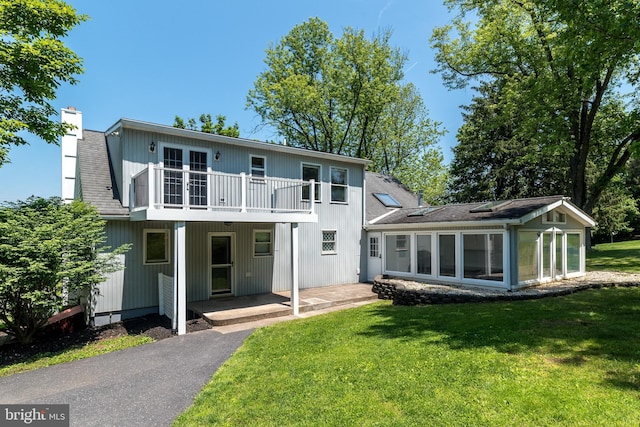 2462 Route Unit 412, Hellertown, PA 18055 - back of property featuring a balcony, a chimney, a lawn, and a sunroom
