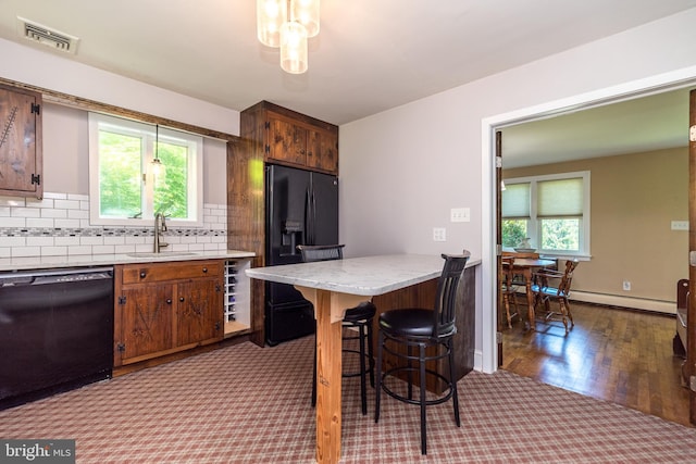 2462 Route Unit 412, Hellertown, PA 18055 - kitchen with black appliances, a baseboard heating unit, dark carpet, decorative backsplash, and a breakfast bar