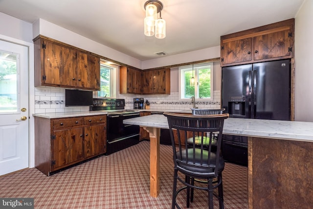 2462 Route Unit 412, Hellertown, PA 18055 - kitchen with black appliances, light countertops, tasteful backsplash, carpet floors, and healthy amount of natural light