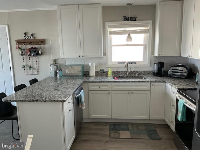 708 Bradley Rd Unit B, Ocean City, MD 21842 - kitchen with a peninsula, white cabinetry, appliances with stainless steel finishes, and decorative backsplash