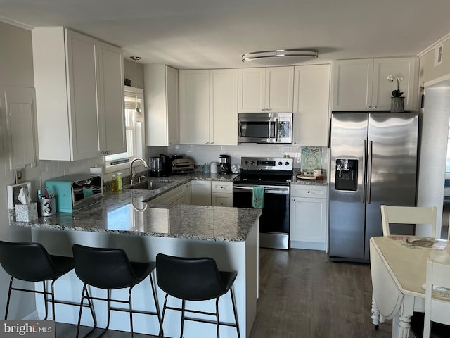 708 Bradley Rd Unit B, Ocean City, MD 21842 - kitchen with stainless steel appliances, a peninsula, stone countertops, white cabinets, and tasteful backsplash
