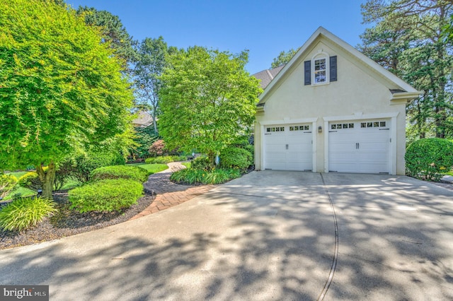18 Knottingham Dr, Voorhees, NJ 08043 - view of home's exterior with stucco siding, a garage, and driveway