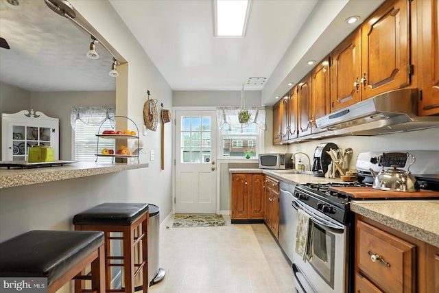 8141 Gray Haven Rd, Baltimore, MD 21222 - kitchen with stainless steel appliances, under cabinet range hood, brown cabinets, light countertops, and recessed lighting