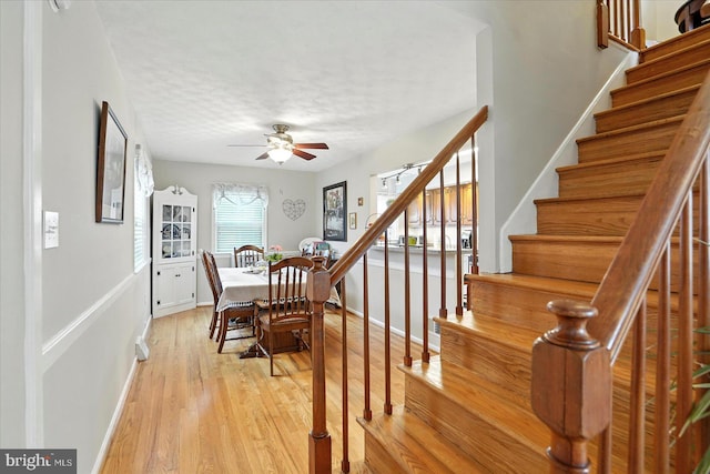8141 Gray Haven Rd, Baltimore, MD 21222 - dining space with stairway, light wood finished floors, a ceiling fan, and a textured ceiling