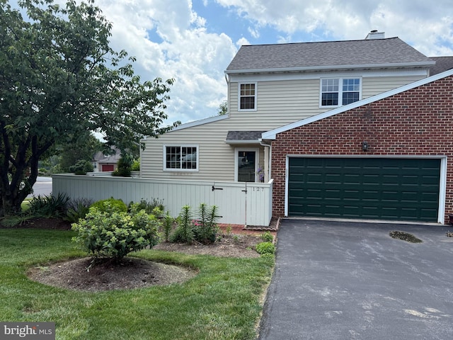 127 Winding Hill Dr, Lancaster, PA 17601 - view of front of home featuring brick siding, driveway, an attached garage, roof with shingles, and a chimney