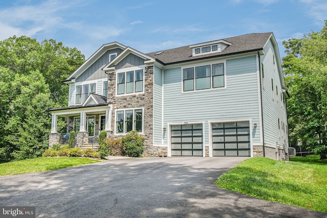 9908 Blake Ln, Oakton, VA 22124 - craftsman inspired home with stone siding, driveway, an attached garage, a front yard, and board and batten siding
