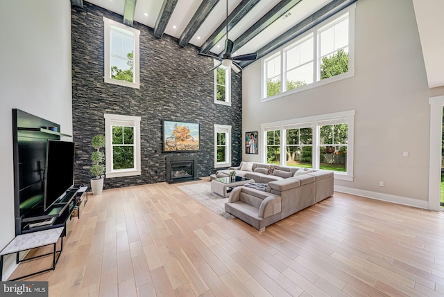 9908 Blake Ln, Oakton, VA 22124 - living area with ceiling fan, a stone fireplace, a towering ceiling, plenty of natural light, and light wood-style flooring