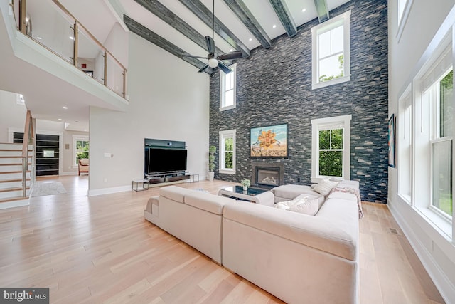9908 Blake Ln, Oakton, VA 22124 - living area featuring a fireplace, a high ceiling, ceiling fan, light wood finished floors, and stairway